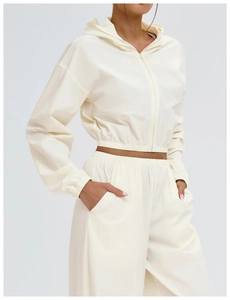 Detail view of cream hooded jacket with elastic cuffs and high-quality waterproof fabric