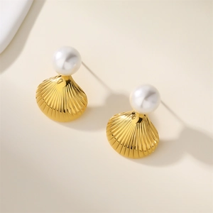 Close-up of golden seashell earring studs with elegant white pearl on a clean background