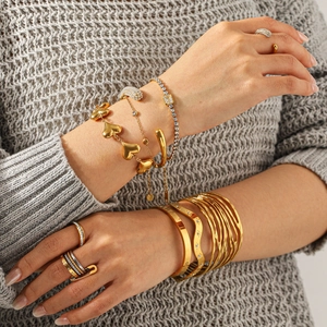Elegant gold heart charm bracelet and zircon ring set styled on model for daily wear