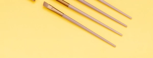 Detailed top view of 13 professional makeup brushes with pink handles and gold ferrules