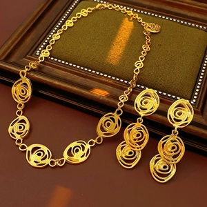 Detailed view of vintage gold flower jewelry set with spiral patterns on wooden tray