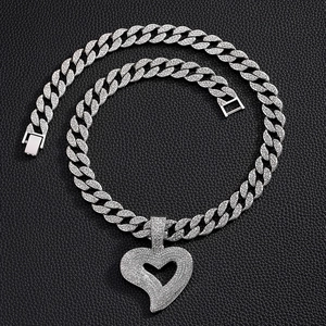 Silver iced-out Cuban chain necklace with sparkling heart pendant on black background