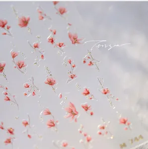 Macro detail of M-744 nail stickers with pink flowers, gold glitter, and textured finish
