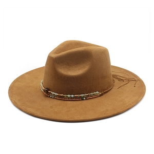 Detail of bohemian beaded band with turquoise accents and fringe on a brown fedora
