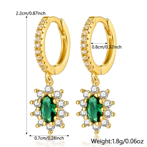 Detailed view of gold hoop earrings with green oval stone and white cubic zirconia accents