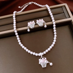 Vue détaillée de l'ensemble de bijoux en perles avec pendentifs panier dans un coffret