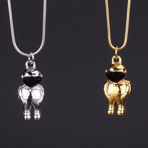 Detail view of silver and gold astronaut pendant necklaces with mirror finish and snake chains