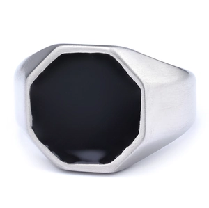 Detailed close-up of octagonal men's signet ring with black enamel and brushed steel texture