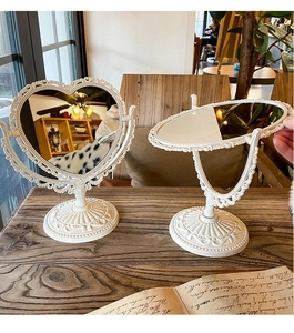 Detail of vintage heart and oval white mirrors with embossed patterns in a cozy cafe setting