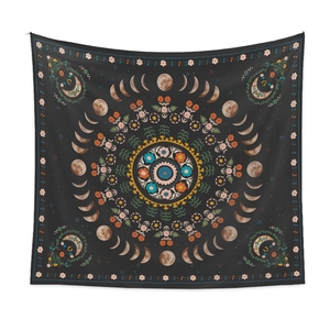 Detail of bohemian moon phase tapestry with floral mandala pattern on dark fabric