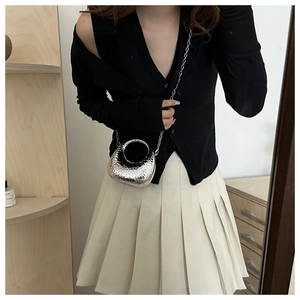 Détail du mini sac argenté à texture martelée avec poignée ronde et bandoulière chaîne