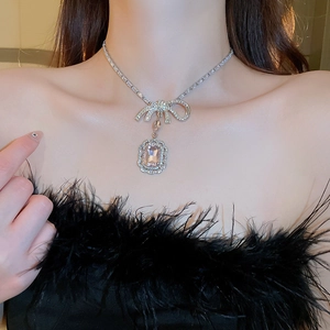 Gros plan du collier nœud élégant avec pendentif en zircon rose porté au cou