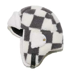 Detail of checkered trapper hat with lamb wool texture and faux fur ear flaps