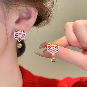 Macro detail of red lion dance earrings with golden bells and fine enamel finish