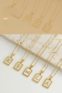 Macro detail of 18K gold-plated stainless steel shell letter pendant necklace collection
