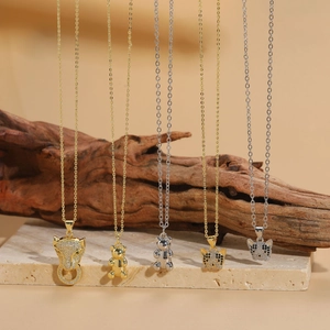Detail of zircon-encrusted leopard and bear pendants with gold and silver finishes