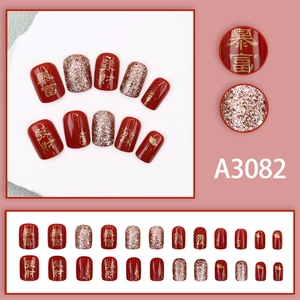 Short red press-on nails with festive gold glitter and Chinese wealth characters