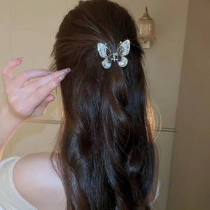 Elegante fermaglio per capelli a farfalla con zirconi viola indossato su capelli lunghi