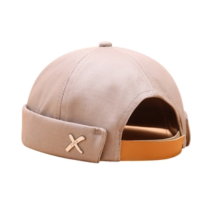 Minimalist light khaki canvas docker hat with vintage metal cross detail for men and women
