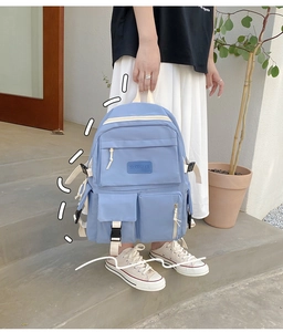 Light blue nylon backpack featuring large utility pockets and a woven brand label