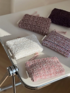 Detail showing five assorted tweed coin purses with woven texture and zipper straps