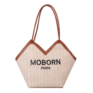 Woven straw tote bag with brown leather trim and MOBORN PARIS logo on white background