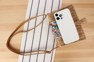 Détail du sac en paille de papier avec broderies de perles et bandoulière en cuir