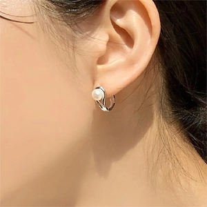 Detailed view of elegant pearl hoop earring in sterling silver worn by a model
