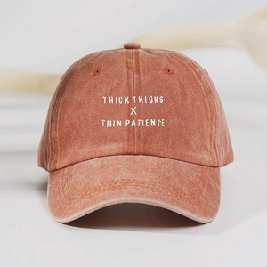 Macro view of brick red washed cotton baseball cap with white embroidery lettering