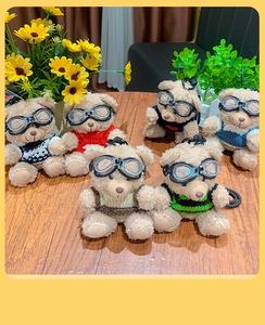 Group of six plush pilot teddy bears with knitted sweaters and goggles on wooden table