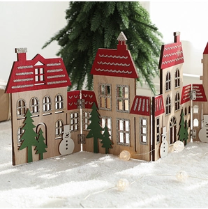 Detail of wooden Christmas house fence with laser-cut patterns and red glitter roofs