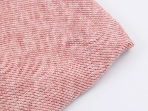 Gros plan détaillé du tissu en maille rose avec bords de couture à double piqûre renforcée