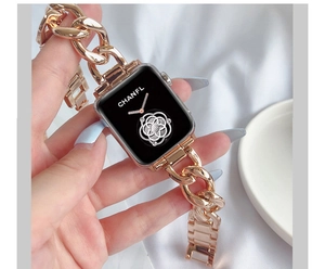 Detail of rose gold metal chain watch band with elegant camellia flower pattern on screen