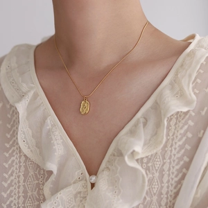 Collier élégant doré vintage avec pendentif rose ovale sur un col en dentelle blanche