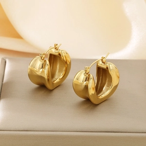 Close-up of heart-shaped 18K gold plated hoop earrings on a luxury jewelry display box
