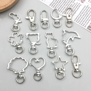 Flat lay of silver metal lobster clasps in heart, star, and flower shapes for DIY jewelry