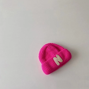 Detail of rose red ribbed knit beanie with cream embroidered letter N for children