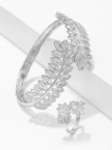 Macro shot of silver feather leaf cuff bracelet and ring set with hollow carving details
