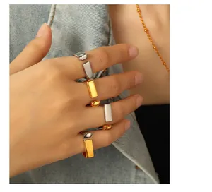 Close-up of minimalist gold and silver geometric open rings with polished finish