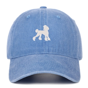 Detailed view of white poodle embroidery on washed blue cotton denim baseball cap