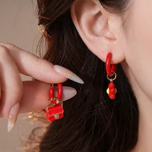 Asymmetric stainless steel red enamel earrings with mini bag and flower pendants