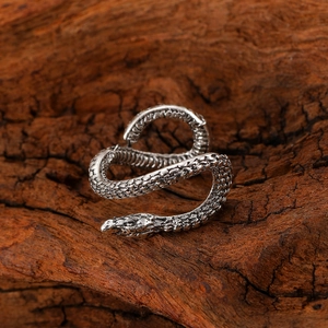 Dettaglio dell'orecchino a forma di serpente argento con scaglie su legno
