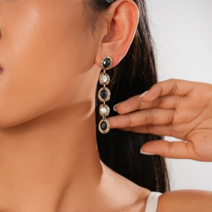 Detail of vintage gold-plated drop earrings with black and white oval stones