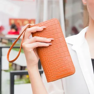 Women's orange crocodile embossed long wallet with wristlet strap and zipper closure