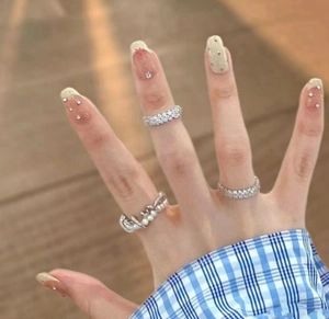 Macro shot of layered silver rings featuring pearls and pavé set cubic zirconia