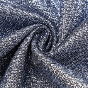 Close-up of deep blue sequin fabric with shimmering metallic glitter and soft drapes