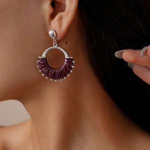 Close-up of vintage deep purple leather wrapped earrings with silver metal accents