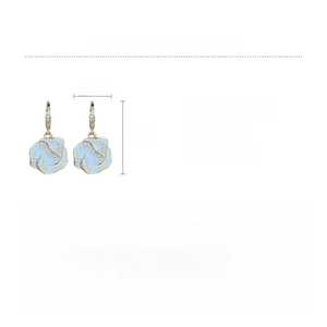 Detailed view of white camellia earrings with gold plating and cubic zirconia inlay