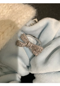 Close-up of silver bow ring featuring trapezoid and round-cut cubic zirconia stones