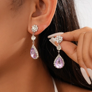 Close-up of lavender teardrop earrings with pave diamonds on model showing luxury detail